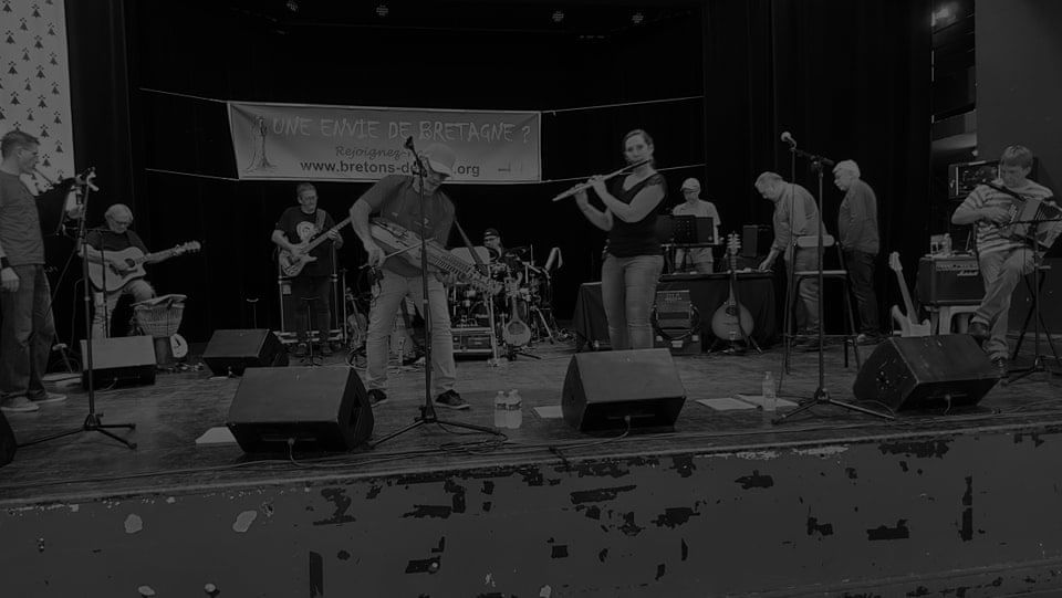 photo en noir et blanc assez sombre du groupe sur scène